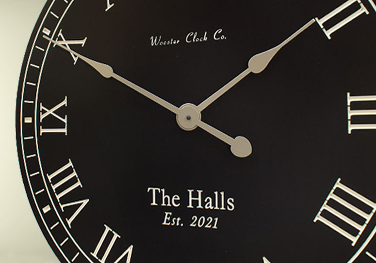 black wall clock with white letters and personalized